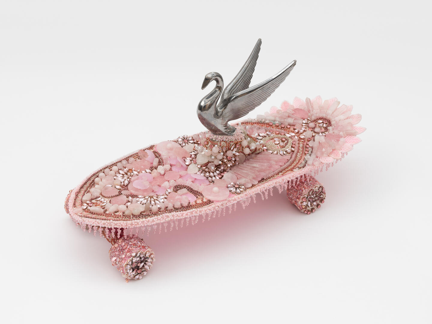 vanessa german, skateboard memorial to tyre nichols who screamed  out for his own mama to come for him while the police  were jumping on his back and taking his name out of  his soul and making him dead with their own  looseness of being and in the brutality of this  separation unaliving him for no reason other than  _________. Well. Or, skateboard as grief, 2023.  Grief, salt, sore throat from all the screaming, shoes  wore out in the soles from marching and begging—  then, a beautiful son gone, a beautiful son and his  name become a hashtag in the ever-expanding digital  memorials of children killed by ..., i don’t really know  what to say y’all, ok: heartbreak, fear, rage, tears,  crane hood ornament, rhinestones, adhesives, cloth,  rose quartz for the how the entire universe is held  together like how a womb. holds an entire human  together within an. Entire human, 31.8 × 66 × 22.9 cm © 2024 vanessa german. Courtesy of the artist and Kasmin, New York; photo by Charlie Rubin 